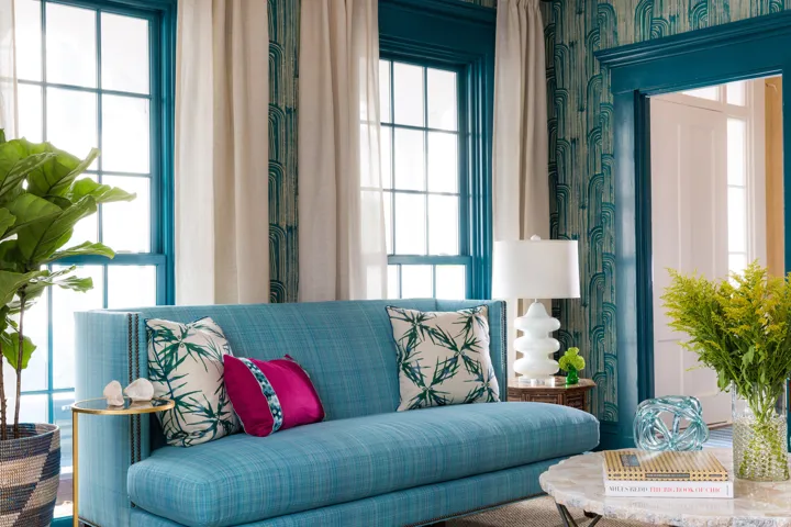 Blue couch in front of large windows in the lounge area of The Christopher