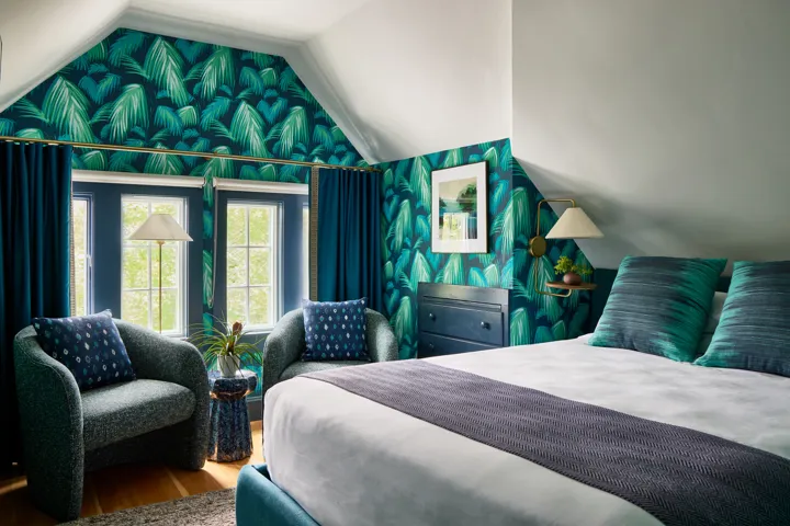 Queen guest room with leaf patterned wallpaper and a sitting area as The Coco