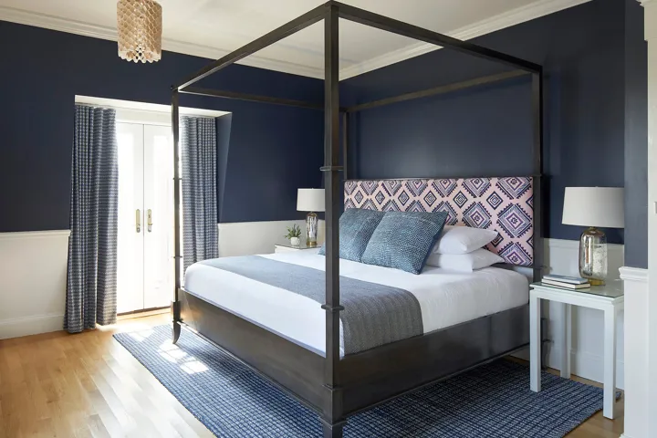 King bed in a guest room that has doors that lead to a private balcony
