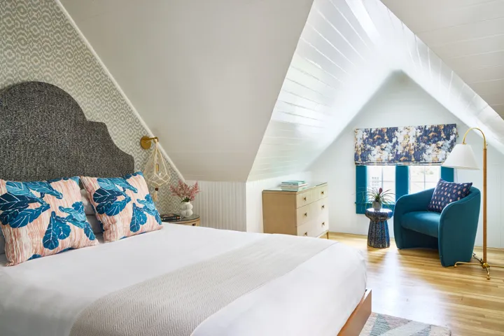 Queen guest room with sitting area that has a comfortable teal chair