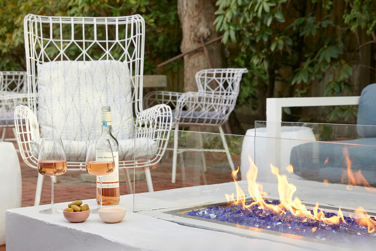 Outdoor firepit with two glasses of wine next to it