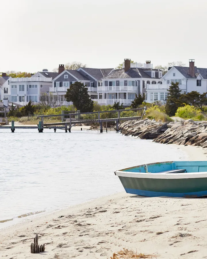 A rowboat tied up and sitting on the sand at a beach
